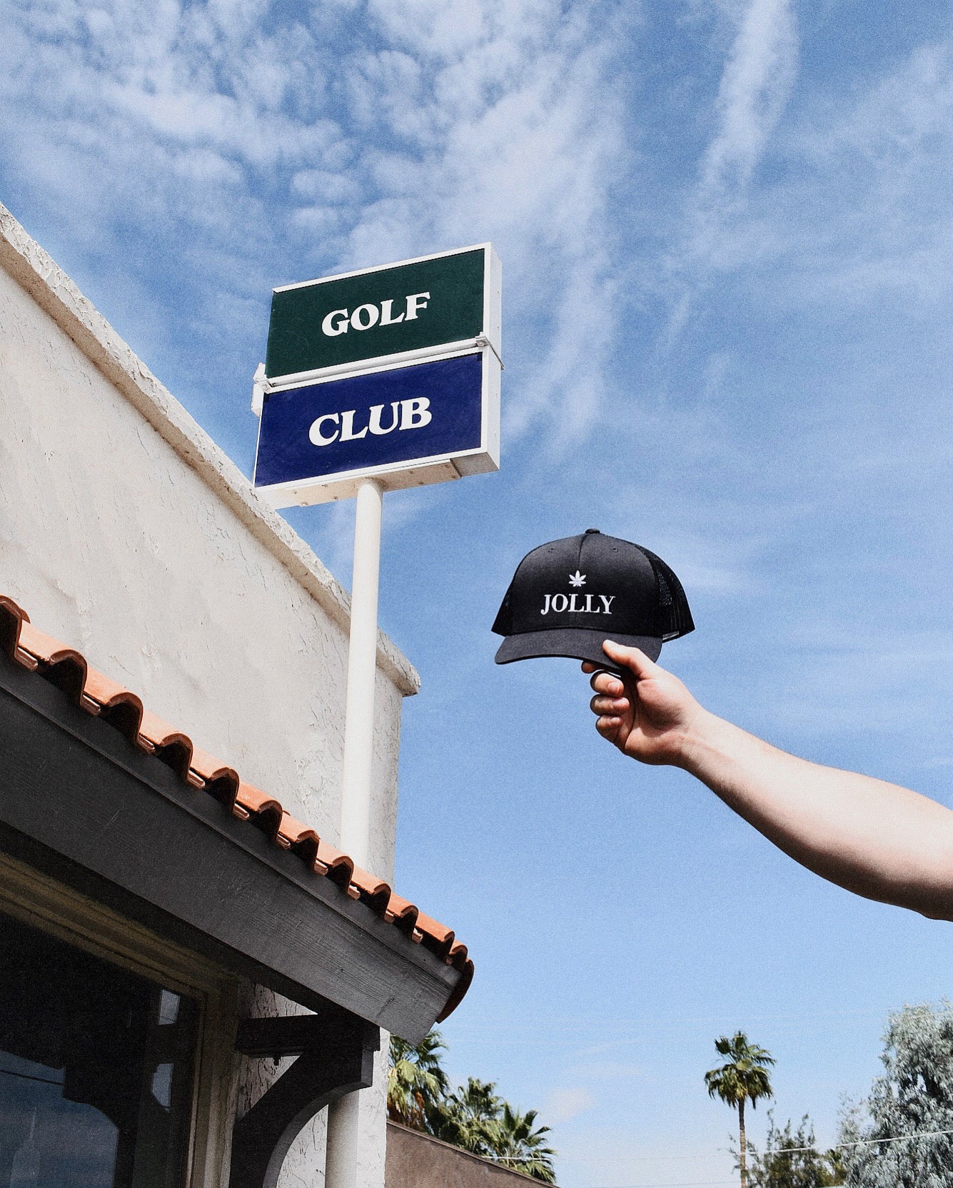 Hand holding a black cap with &