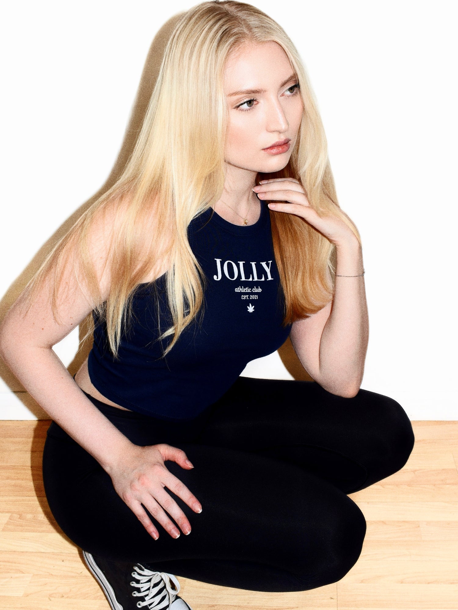 BLONDE MODEL WEARING A JOLLY ATHLETIC CLUB TANK TOP BY JOLLY CANNABIS. MEET YOUR HIGH STANDARDS. STAY JOLLY.